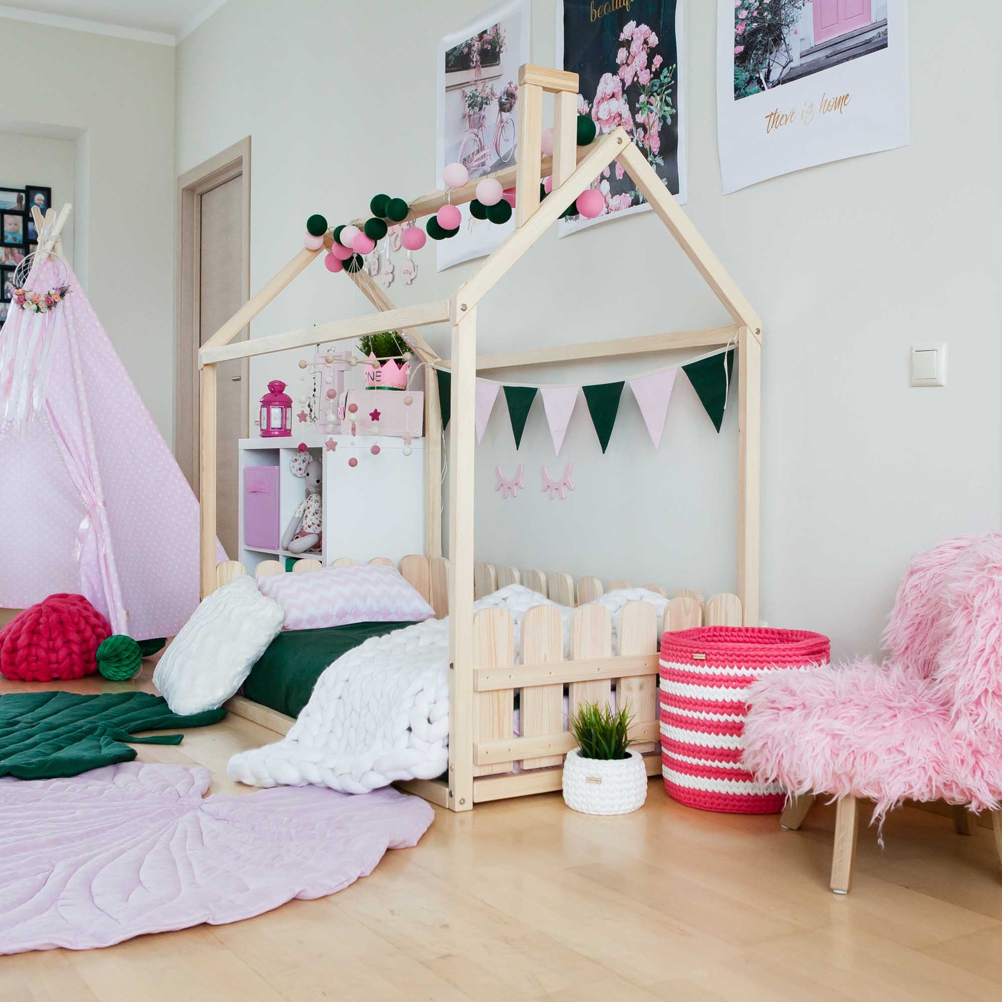 A girl's room with a pink montessori house bed and a pink teepee is now a girl's room with a pink floor house-frame bed with 3-sided picket fence rails and a pink teepee.