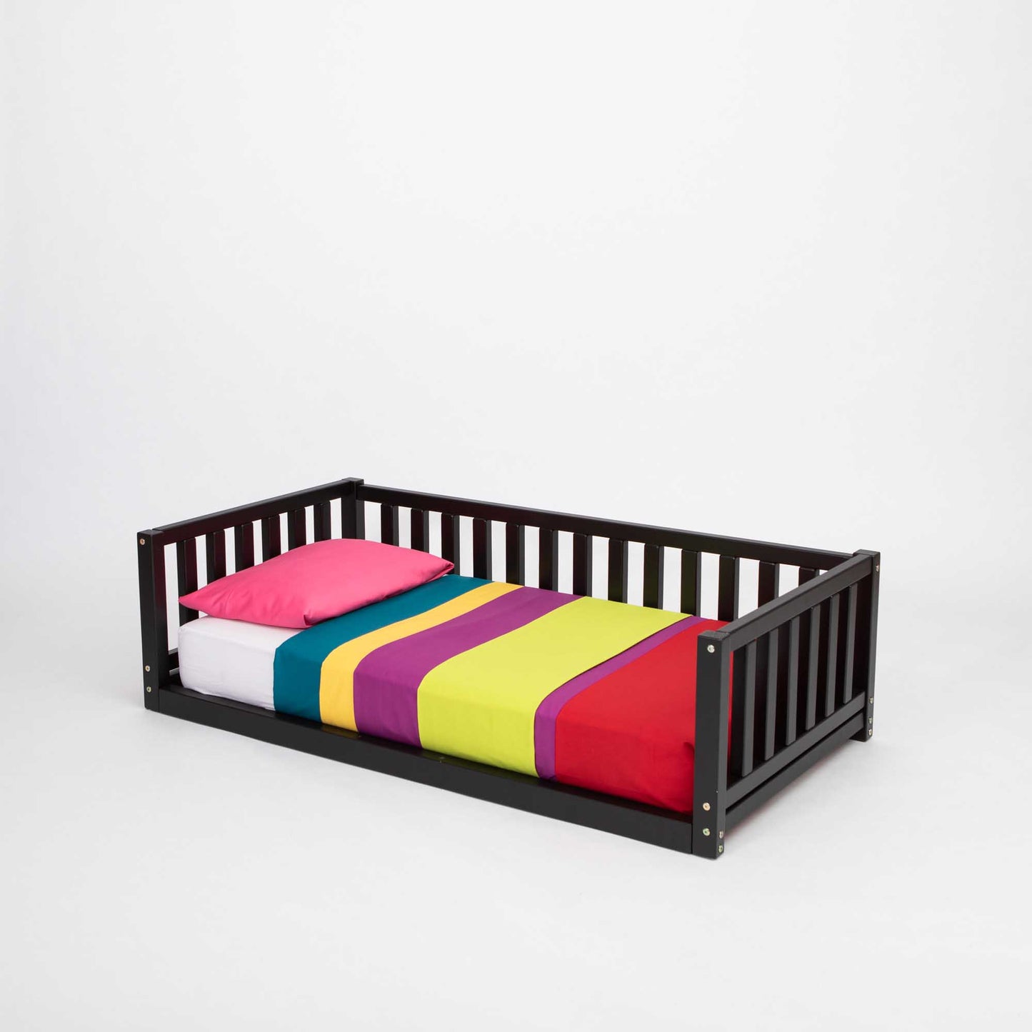 A Sweet Home From Wood 2-in-1 toddler bed on legs with a 3-sided vertical rail and colorful striped sheets.