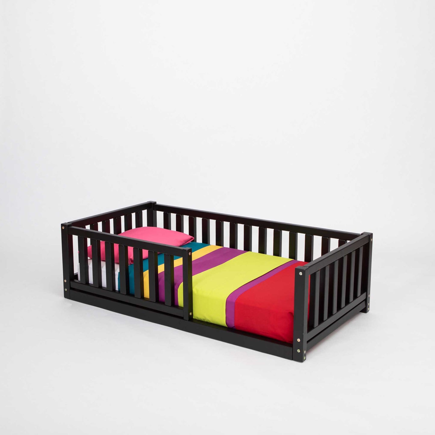 A long-lasting Sweet Home From Wood 2-in-1 toddler bed on legs with a vertical rail fence made of solid pine with a colorful striped sheet.