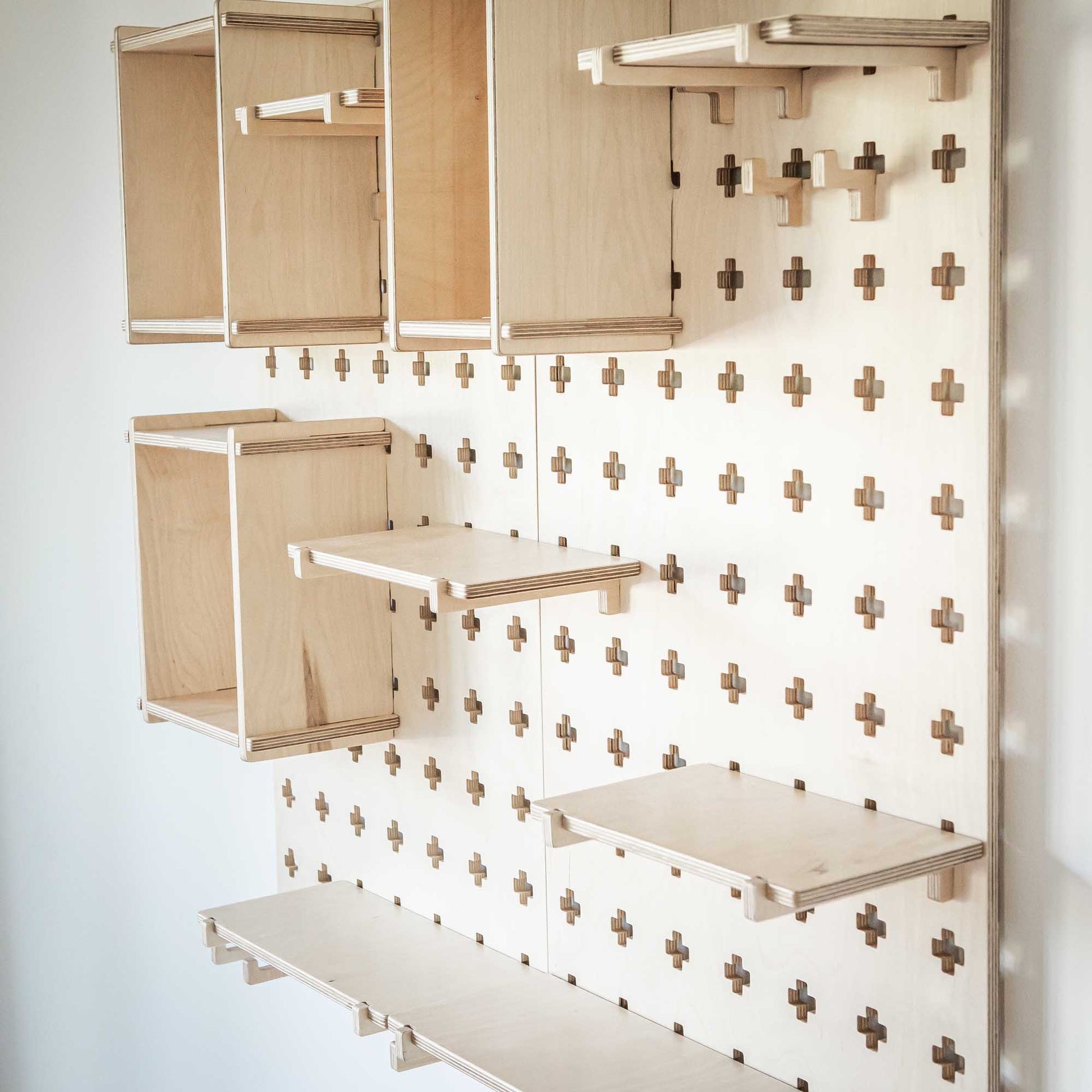 A Large Pegboard Display Stand from Sweet HOME from wood, providing open storage shelves with a cross on it.