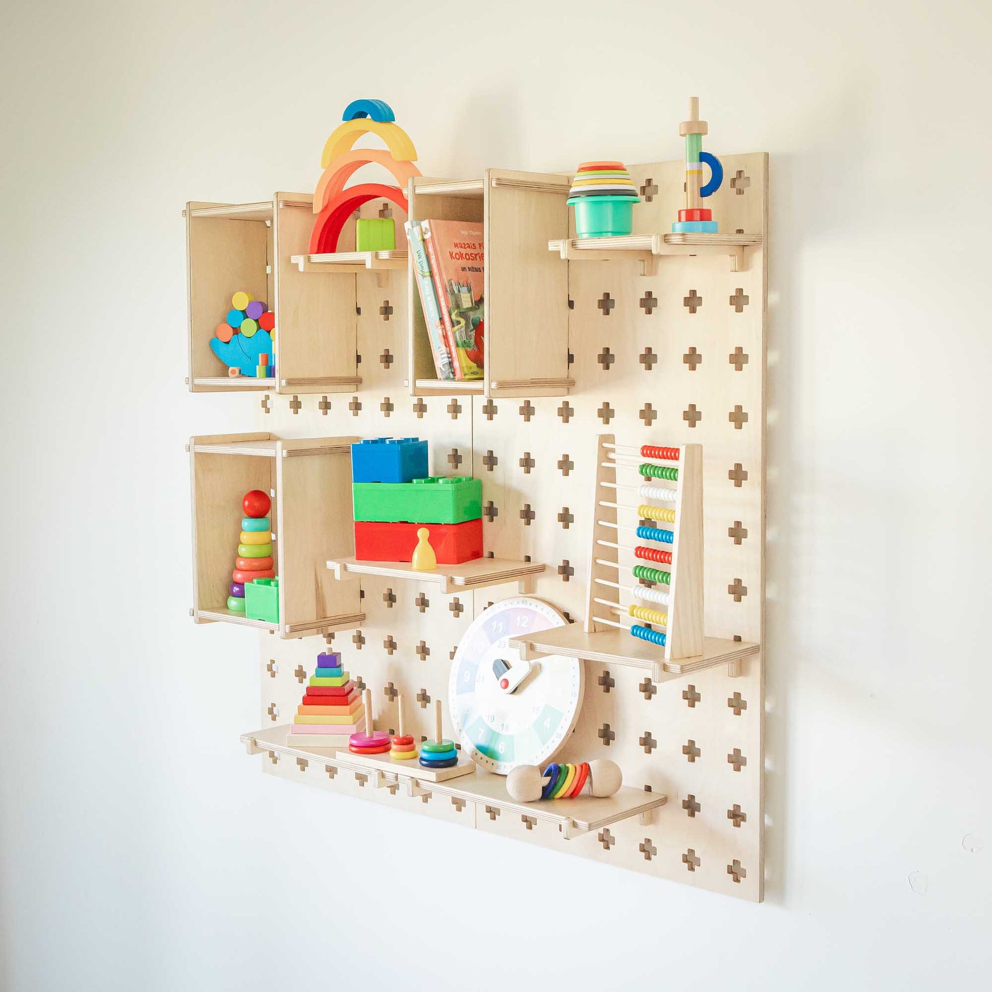 An open Large Pegboard Display Stand with Sweet HOME from wood toddler toys hanging on it.