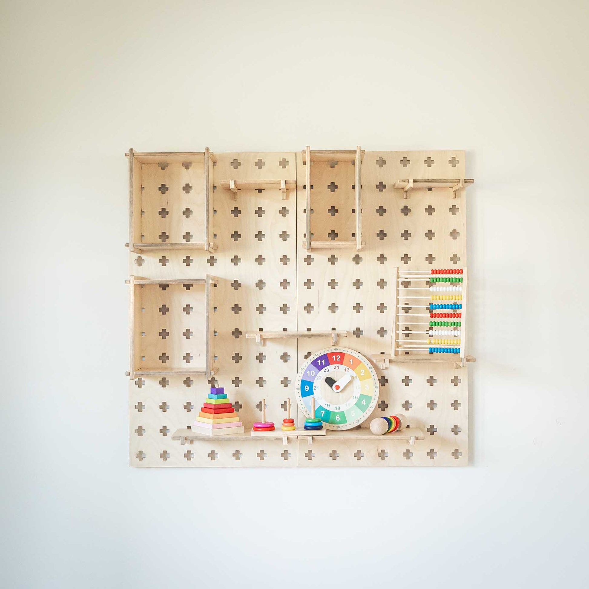 A Large Pegboard Display Stand with Sweet HOME from wood toys hanging on it.