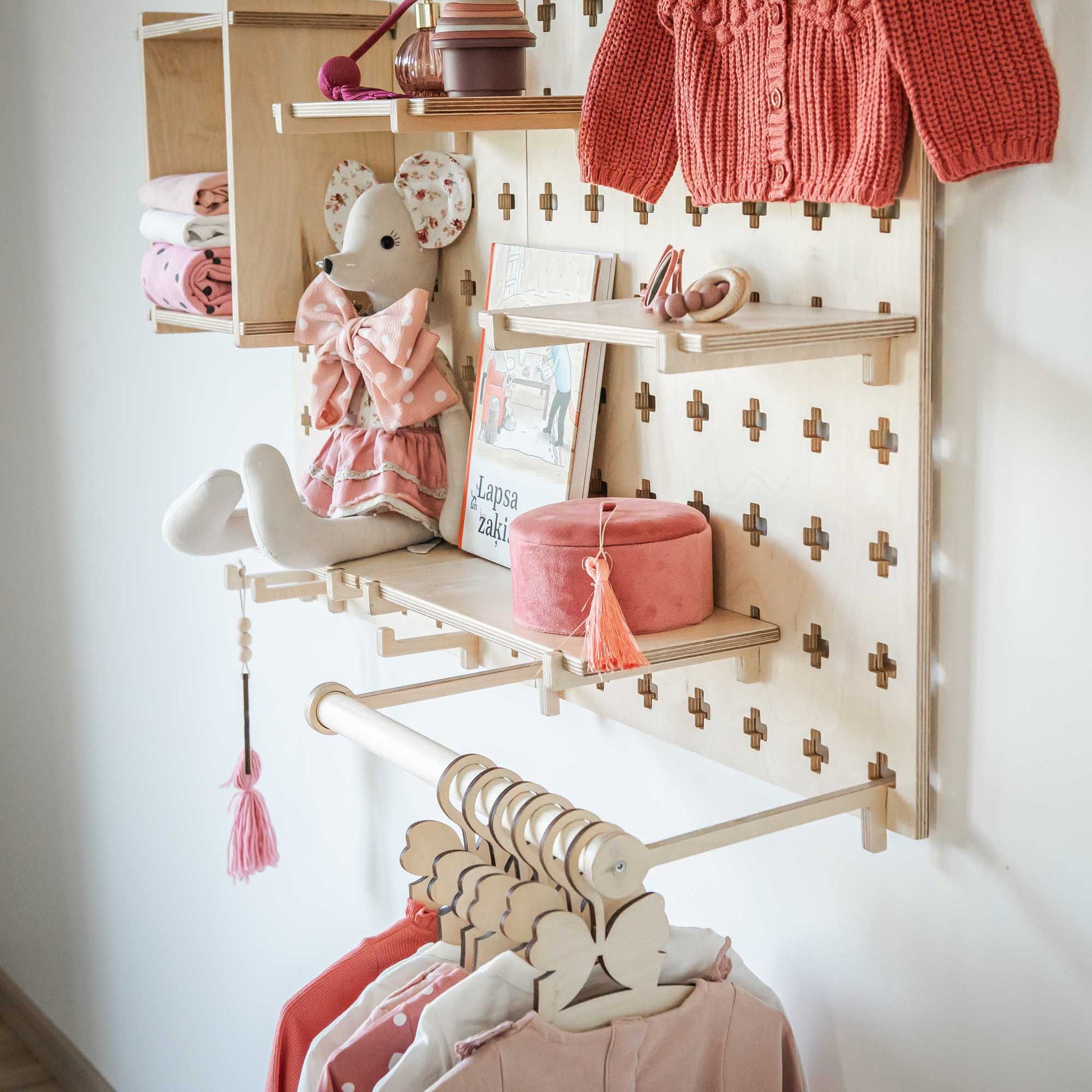 A child's room with toys hanging on the wall using a Sweet HOME from wood Large Pegboard Shelf with Clothes Hanger.