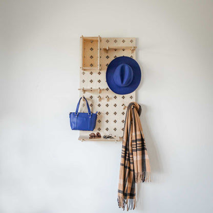 A Sweet HOME from wood Floating Shelves Pegboard with hats, scarves, and bags gracefully hanging on it.