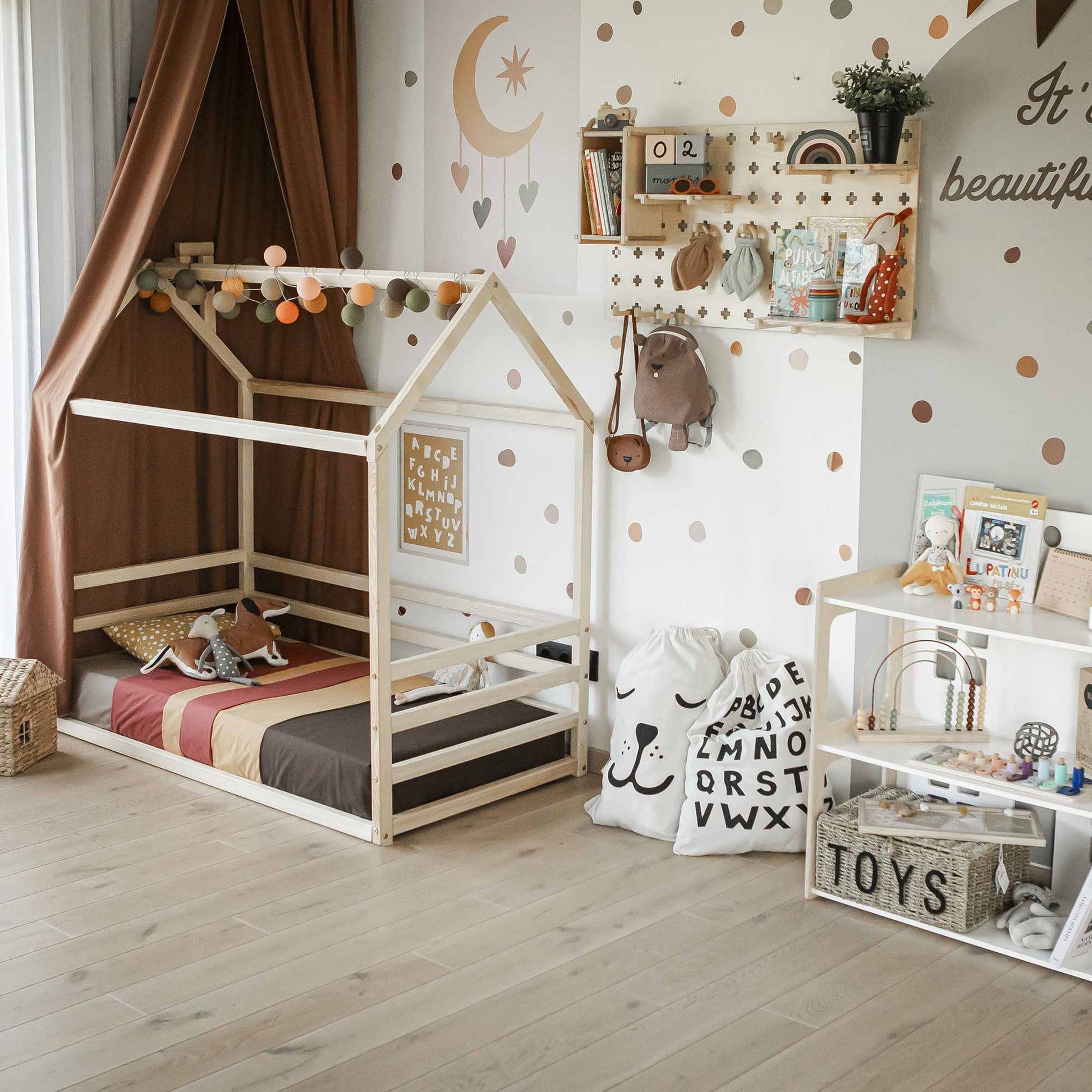 A child's bedroom with a wooden house-frame bed, wall decorations, toys on Floating Shelves Pegboard, and a playful, organized atmosphere.