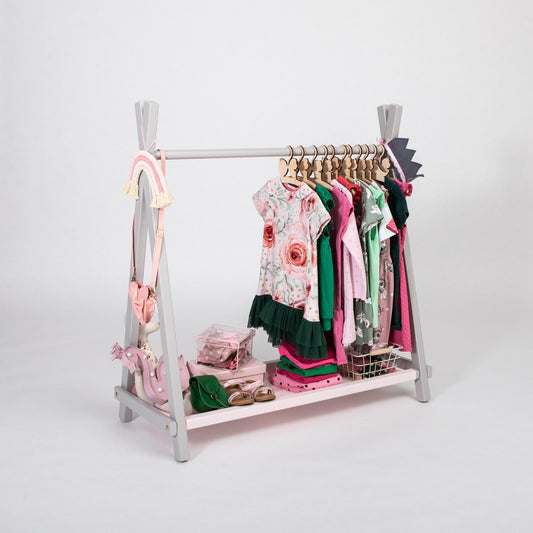 Open wardrobe clothing rack for kids in grey with a pink fabric shelf, displaying children's clothes and accessories.