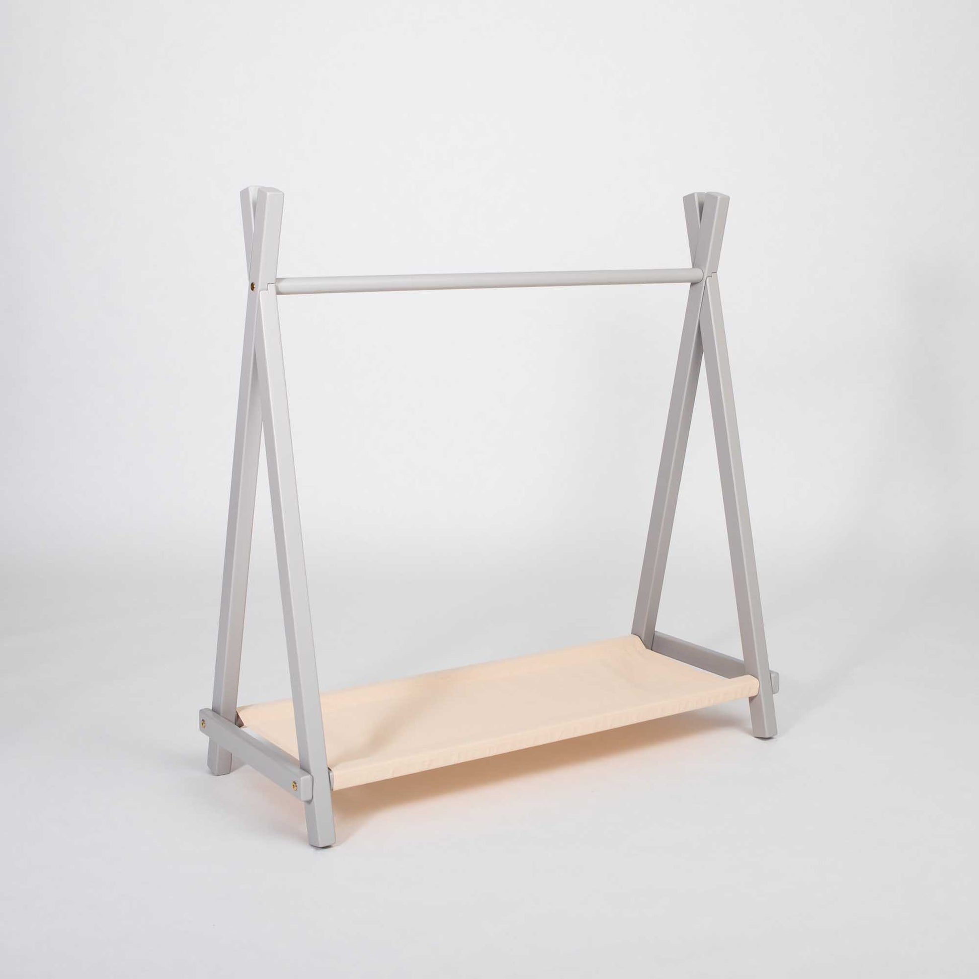 A Montessori-inspired Kids' clothing rack with storage featuring a shelf for convenient storage in a bedroom.