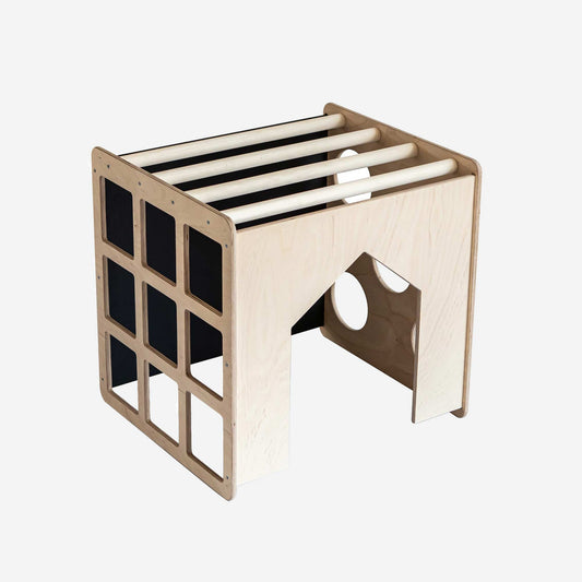 A wooden play table with an activity cube with sensory panels, indoor climber, and Montessori climber from Sweet Home From Wood.