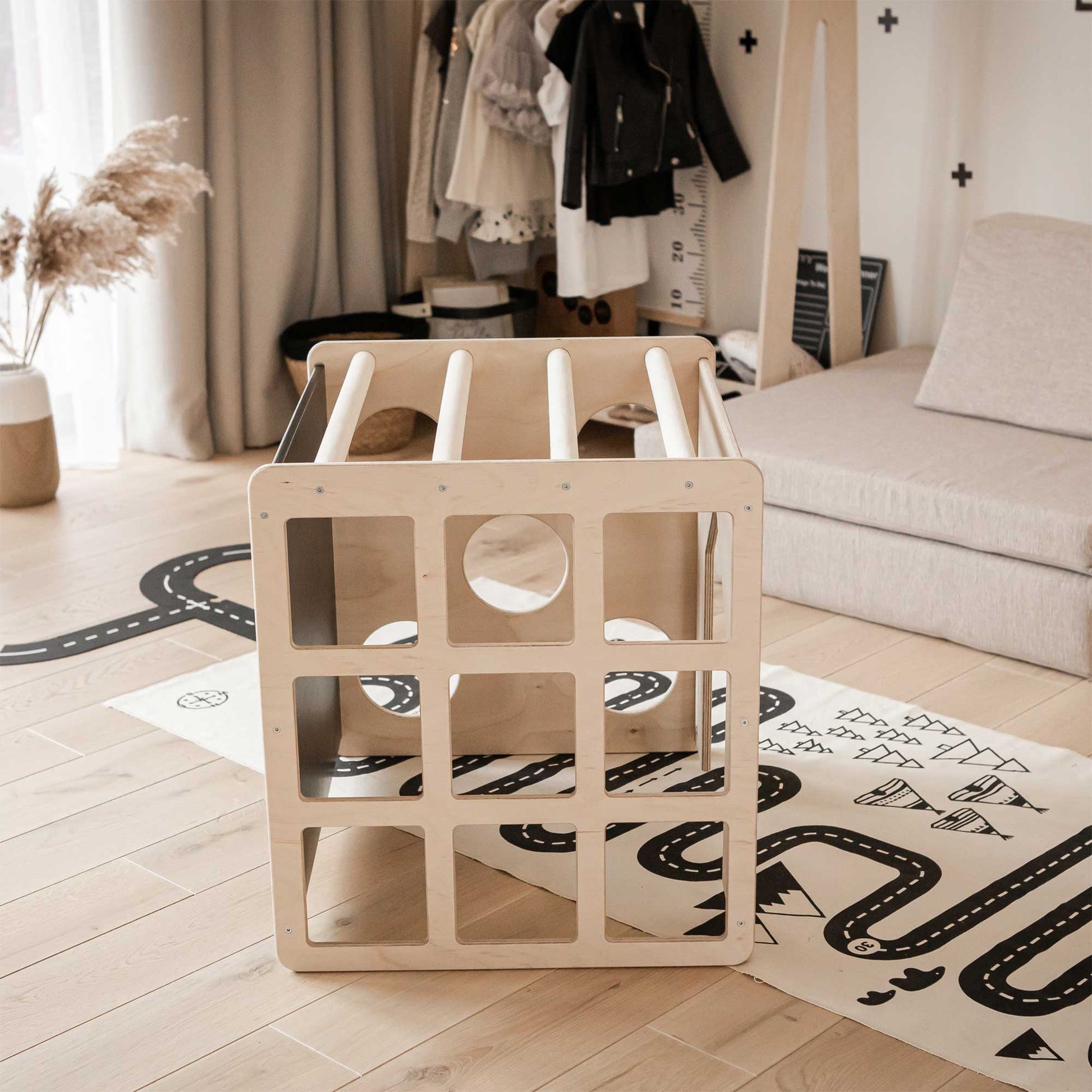 A child's room with a Sweet Home From Wood activity cube with sensory panels on the floor.