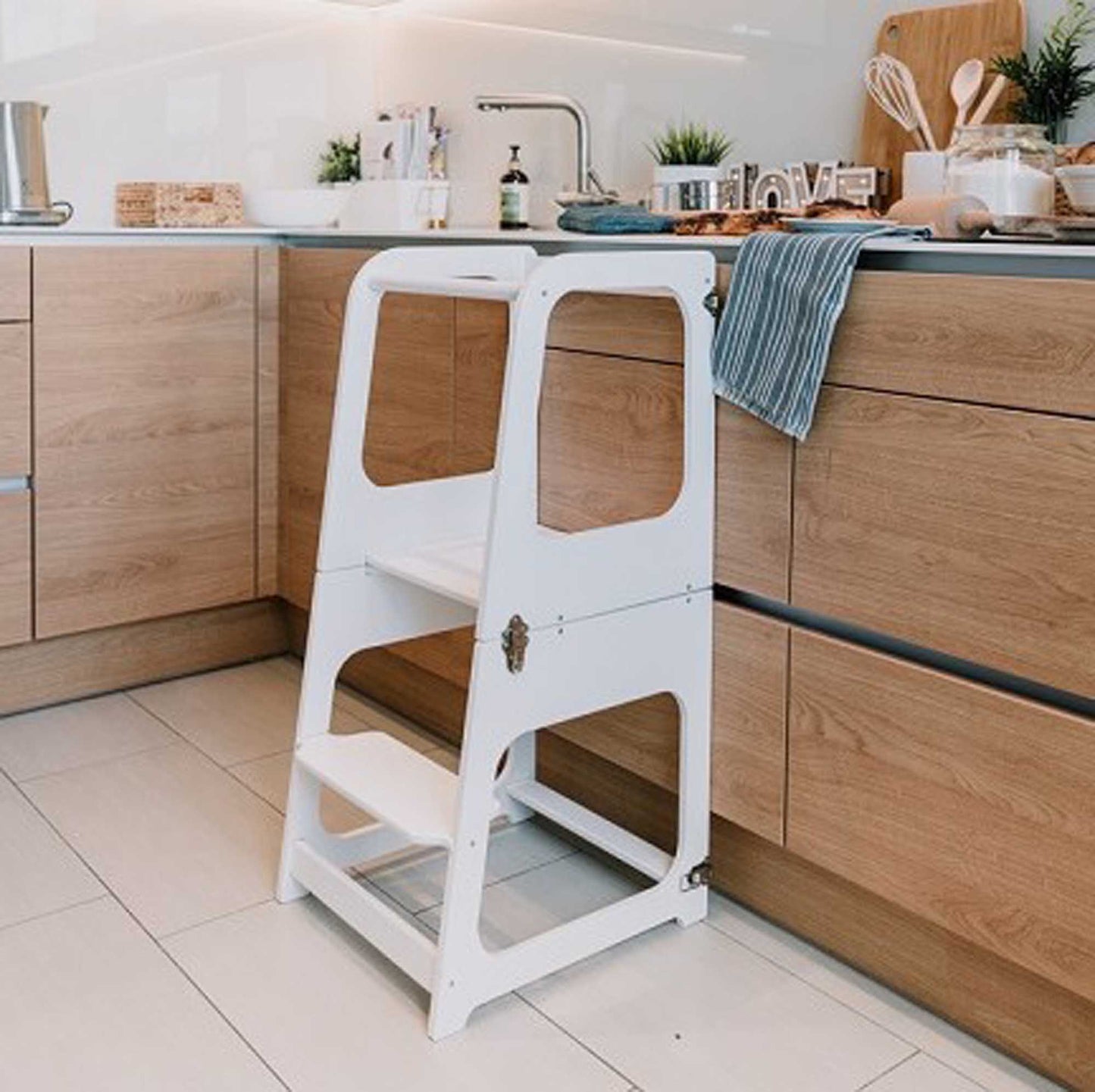 A 2-in-1 Convertible kitchen tower - table and chair in a kitchen, perfect for toddlers.