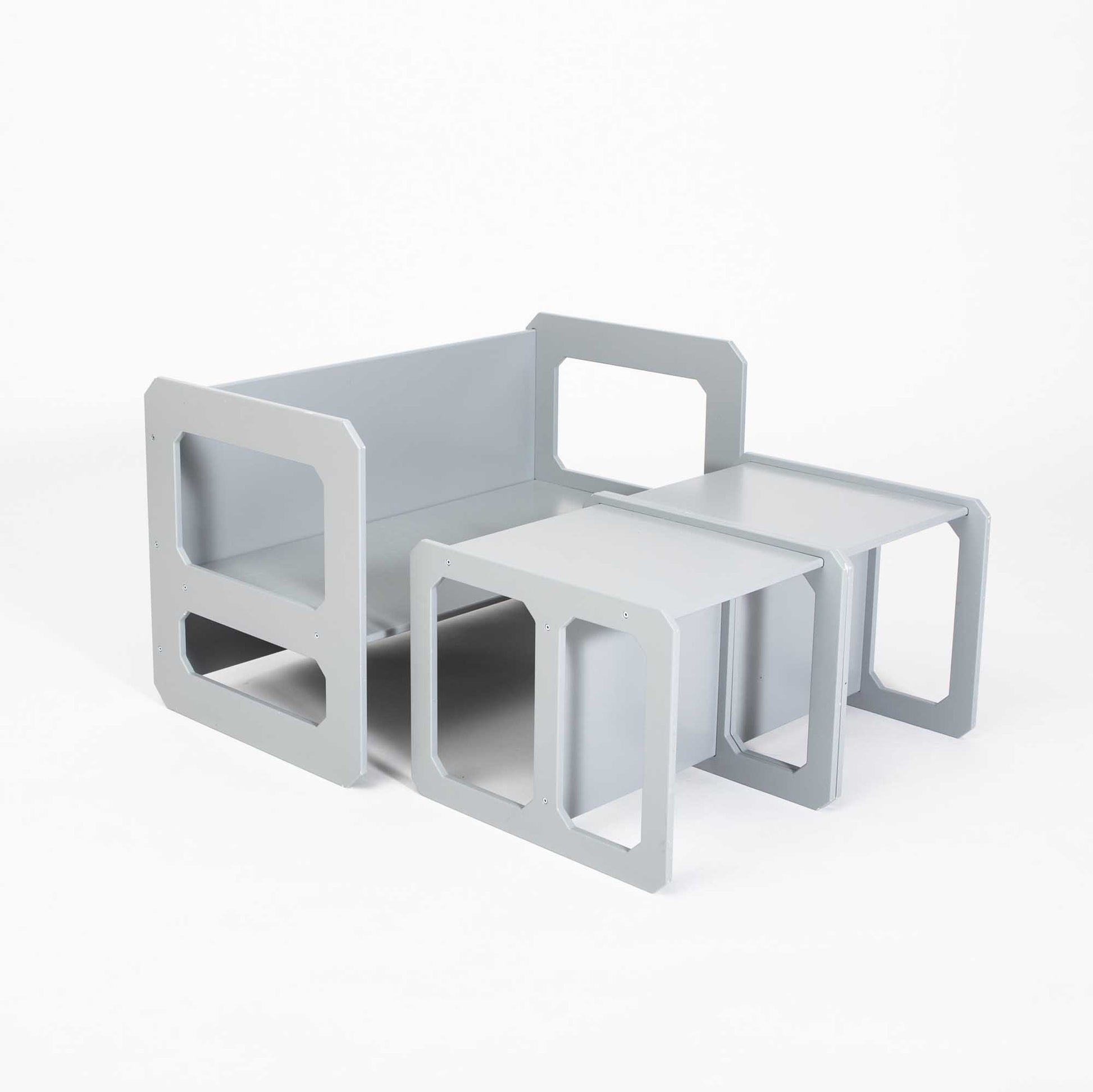A grey sofa with a Montessori weaning table and 2 chair set on top.