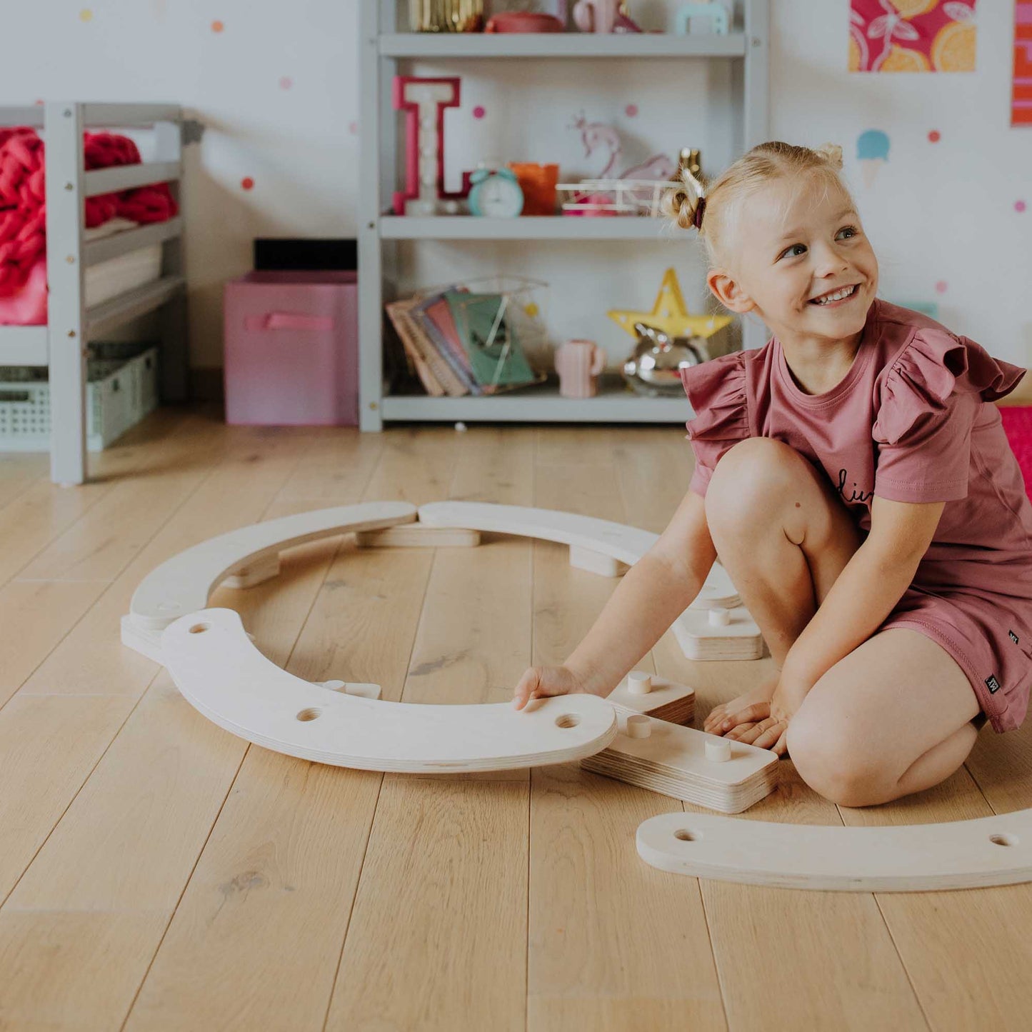 A little girl playing with Round balance beams in a room.