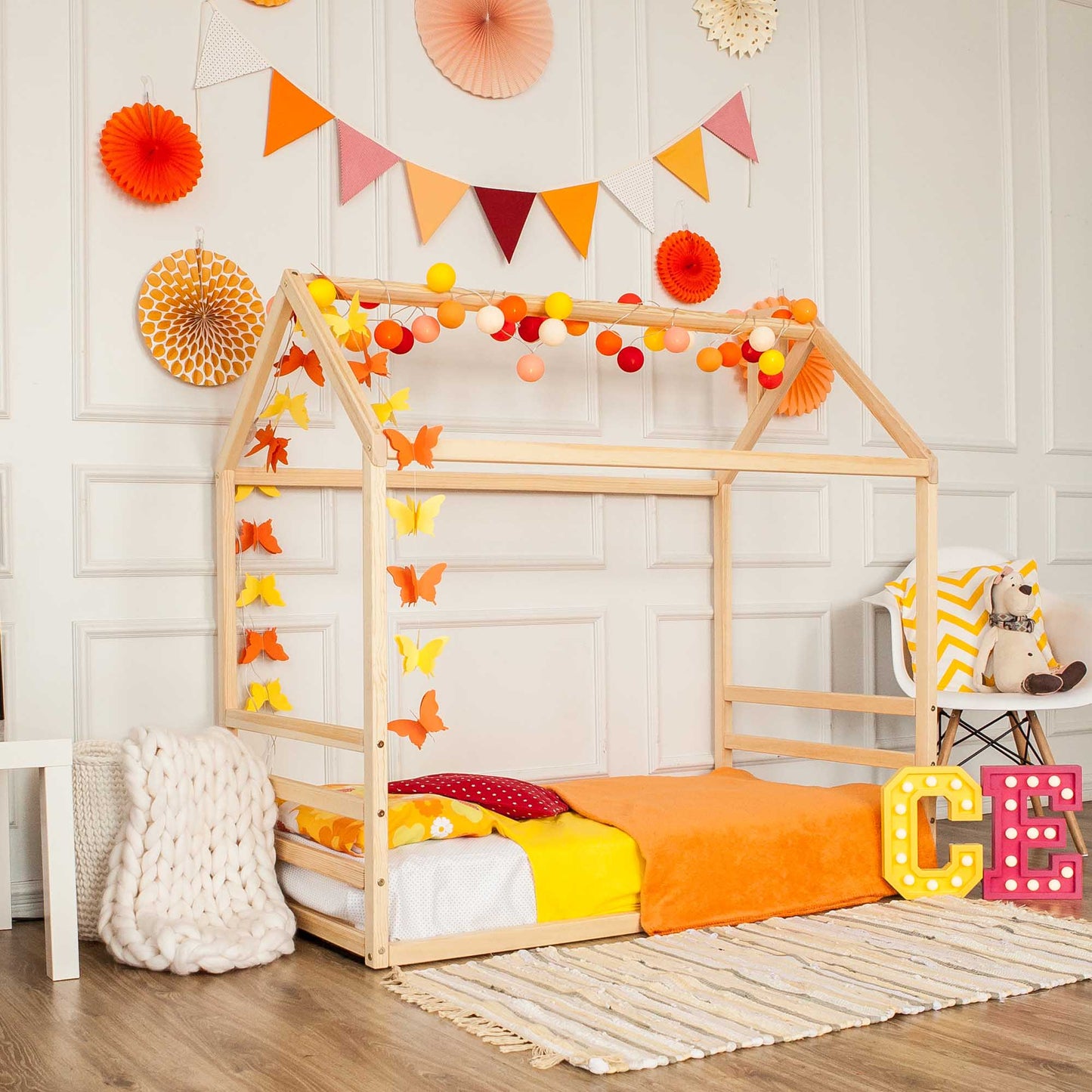 A child's room with a Floor house-frame bed with a horizontal headboard and footboard.
