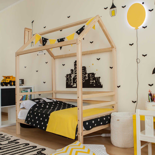 A black and yellow bedroom with a Children's house bed on legs with 3-sided rails and a bedside table.