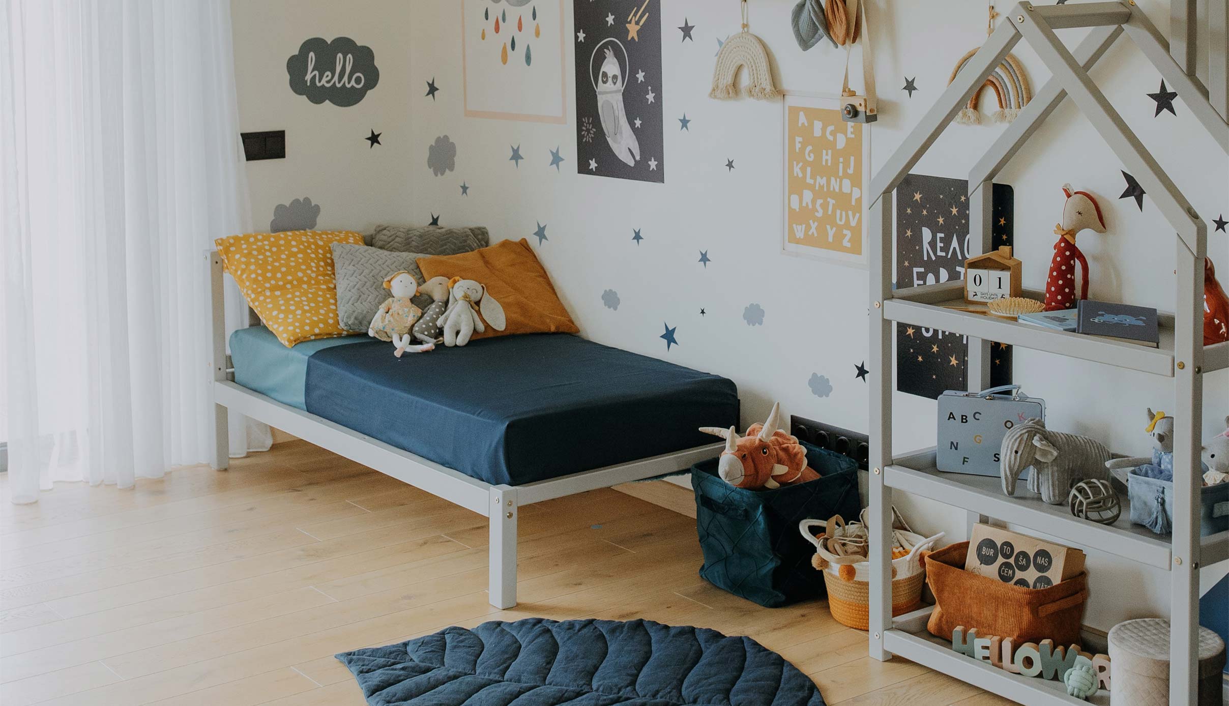 A child's room with a bed, a bedside table, and a rug.
