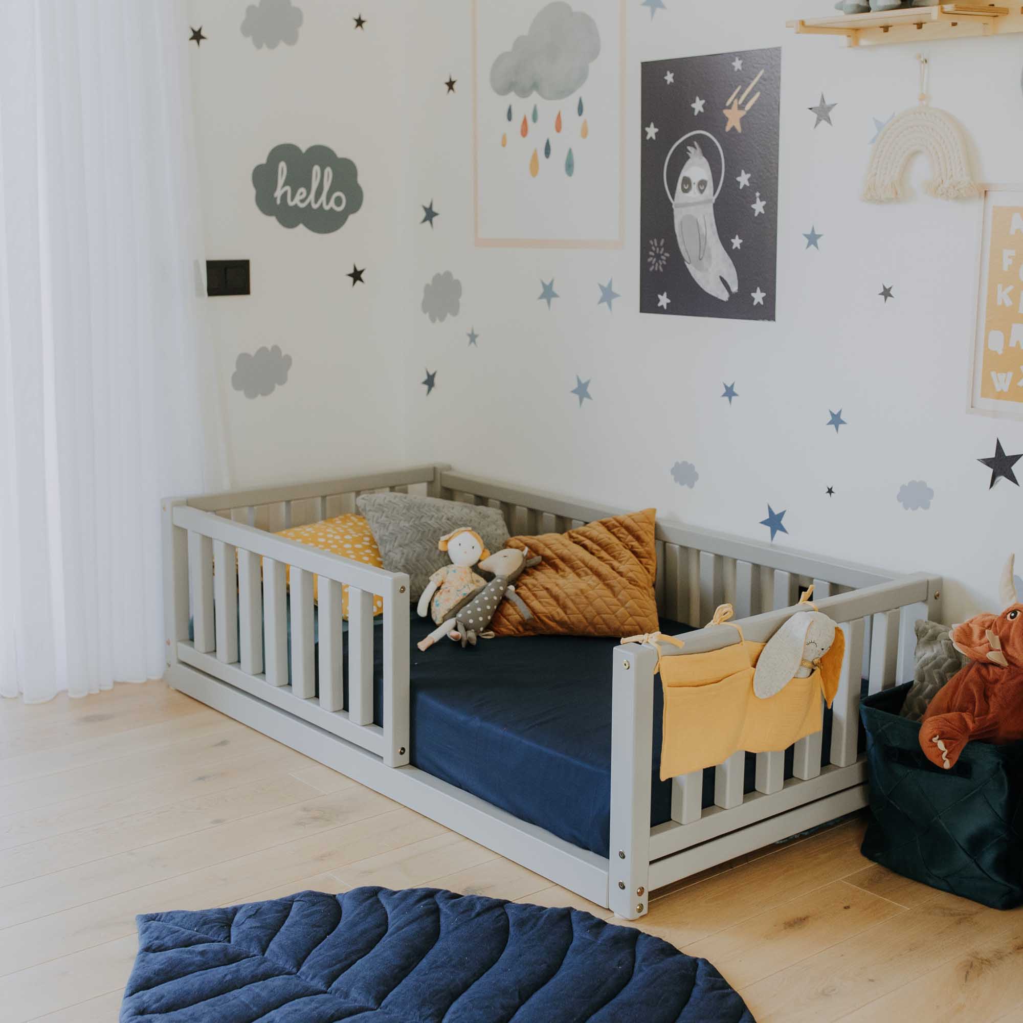 A child's room with a bed and a blue rug.