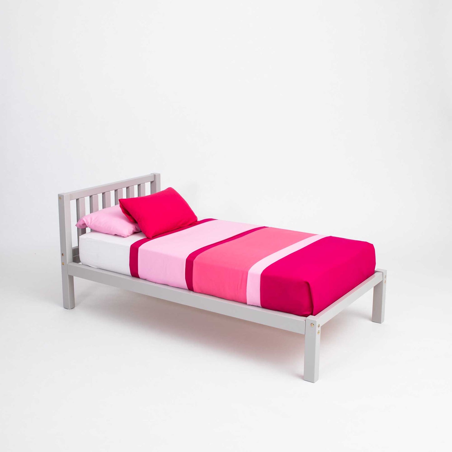 A pink and white Sweet Home From Wood Montessori bed with a grey frame, kids' bed on legs with a headboard.