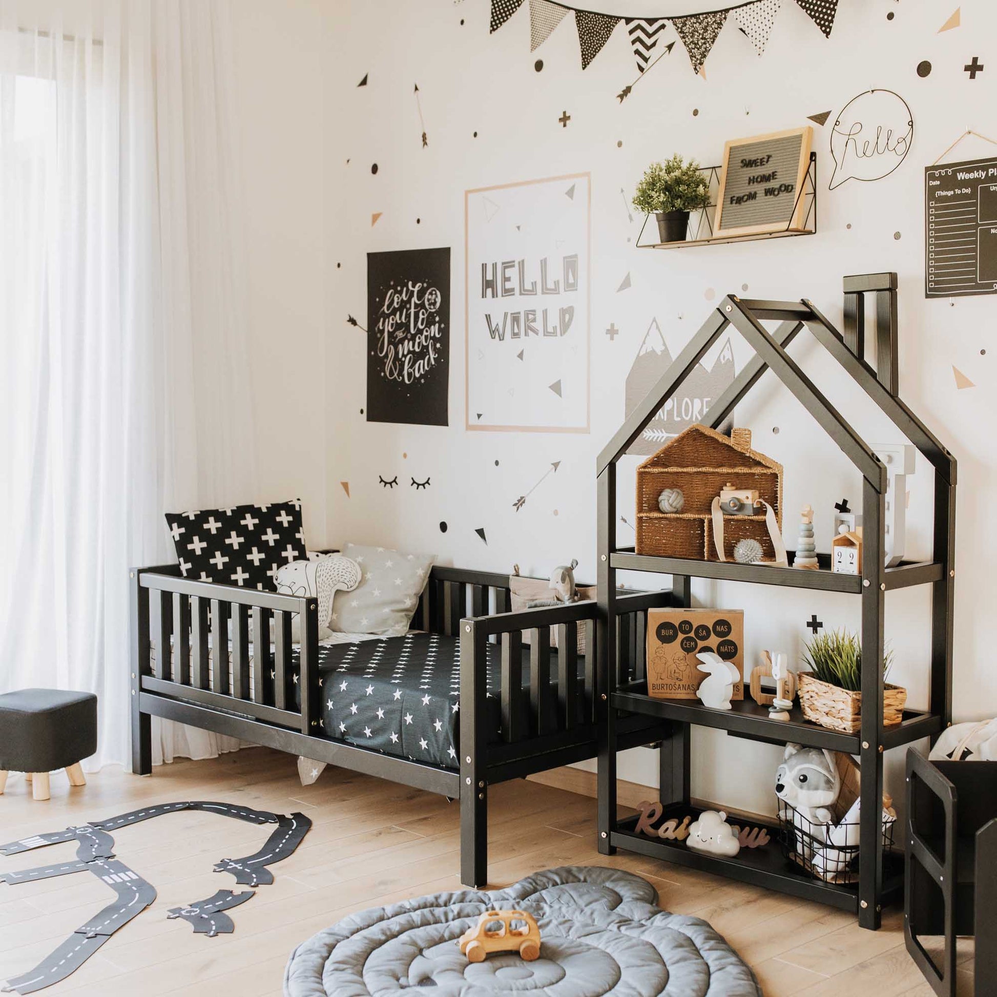 A long-lasting 2-in-1 toddler bed on legs with a vertical rail fence in a boy's room with black and white decor, from the brand Sweet Home From Wood.