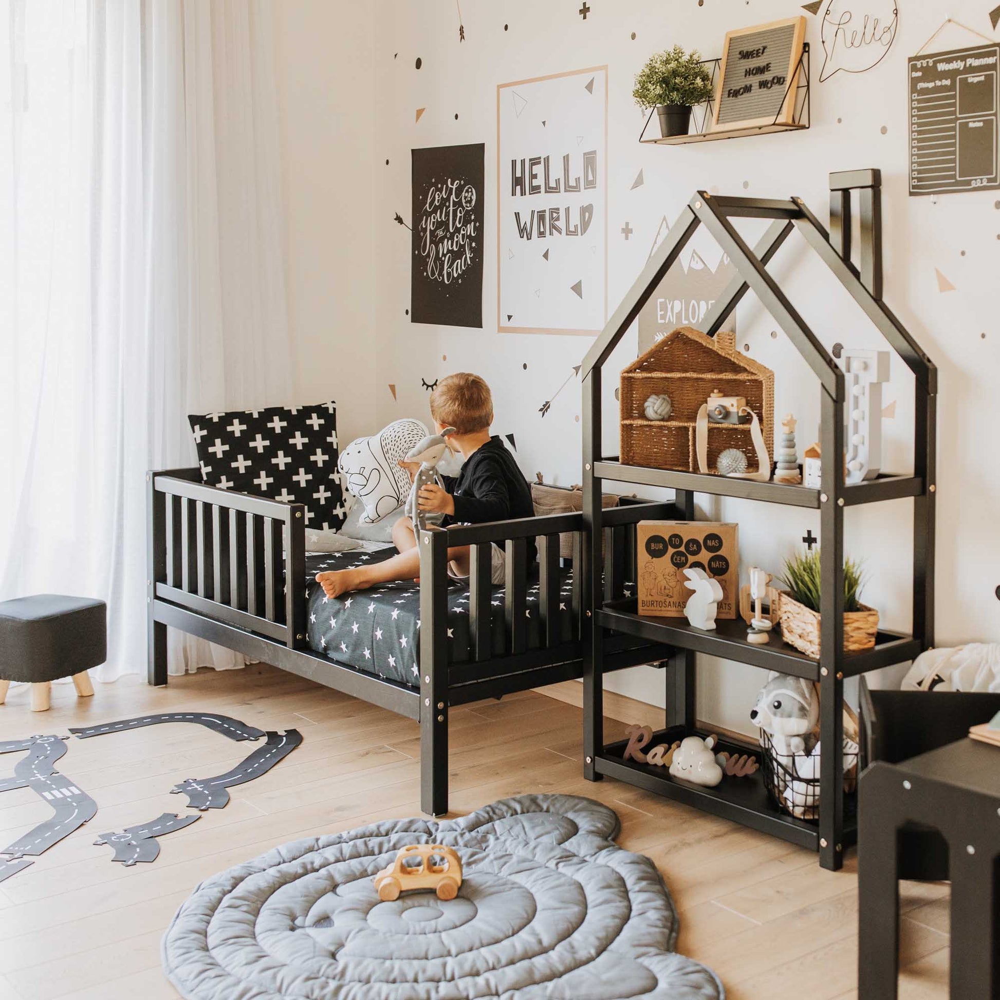 A boy's room with a black and white theme featuring a Sweet Home From Wood 2-in-1 toddler bed on legs with a vertical rail fence.