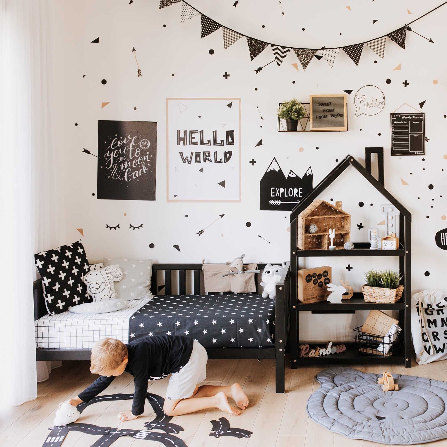 A child's room decorated with black and white polka dots, featuring a Sweet Home From Wood 2-in-1 toddler bed on legs with a 3-sided vertical rail.