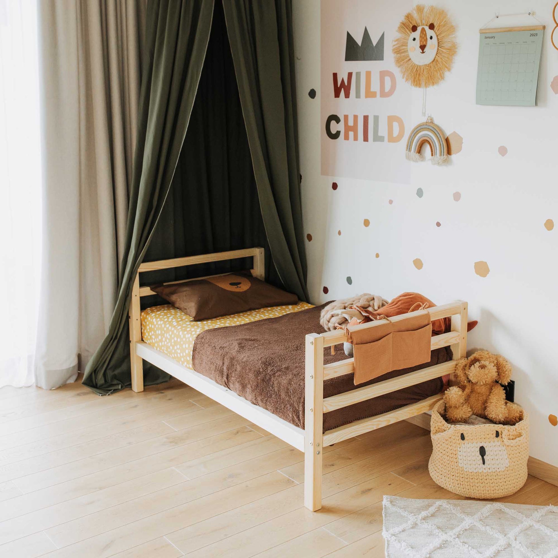 A child's room with a Sweet Home From Wood Kids' bed on legs with a horizontal rail headboard and footboard and teddy bears.