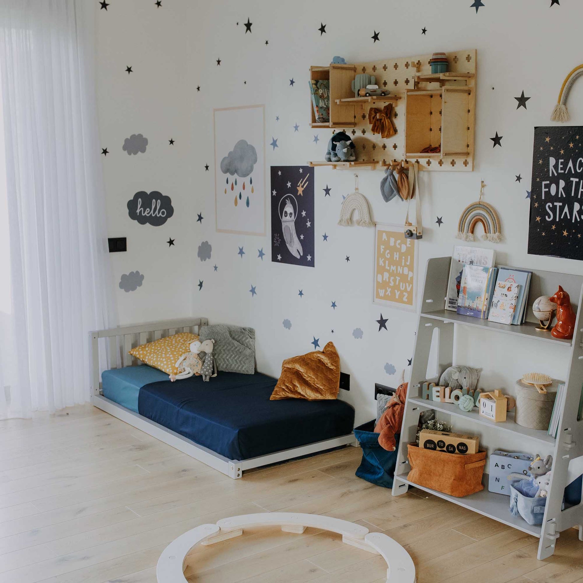 A child's room with a Sweet Home From Wood Montessori bed and a shelf.