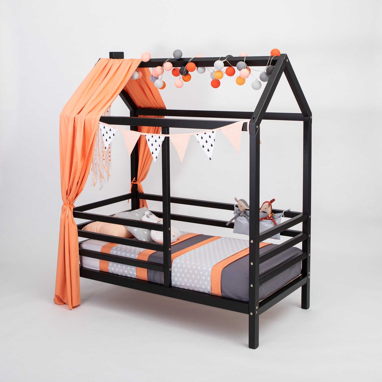 A black and orange wooden house bed on legs with a fence, raised on legs.