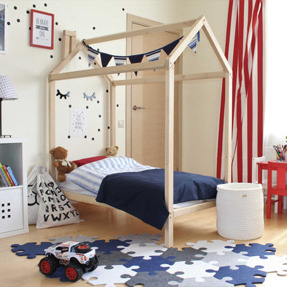 A child's room with a Toddlers' house bed on legs with a headboard and toys.