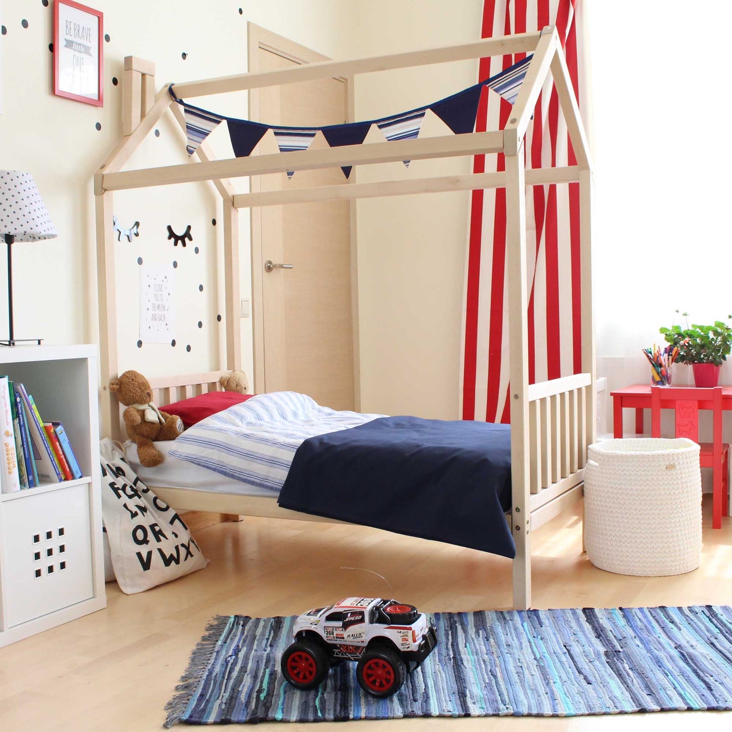 A Toddler house bed on legs with a headboard and footboard in a child's room.