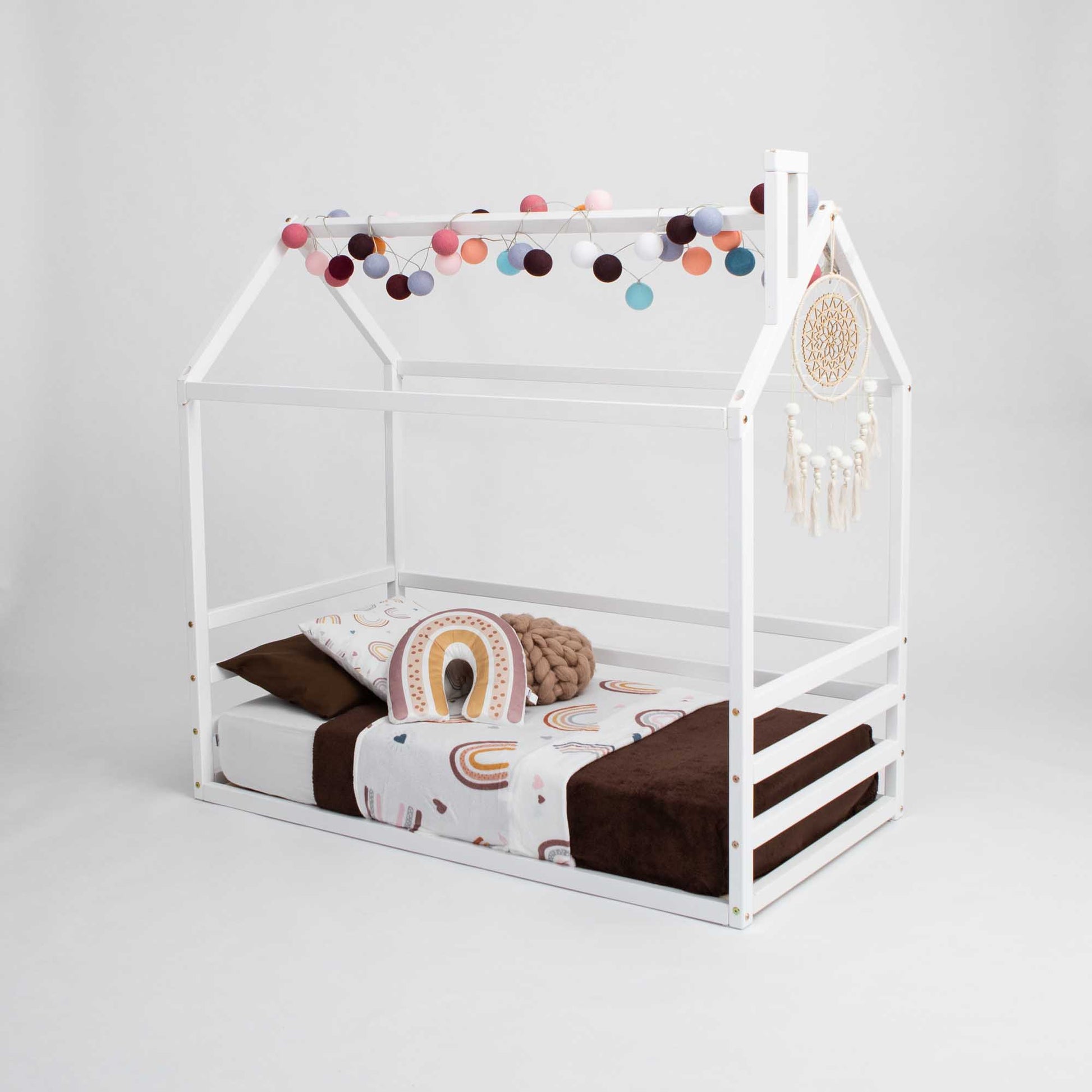 A Kids' house-frame bed with 3-sided horizontal rails and pom poms for toddlers.