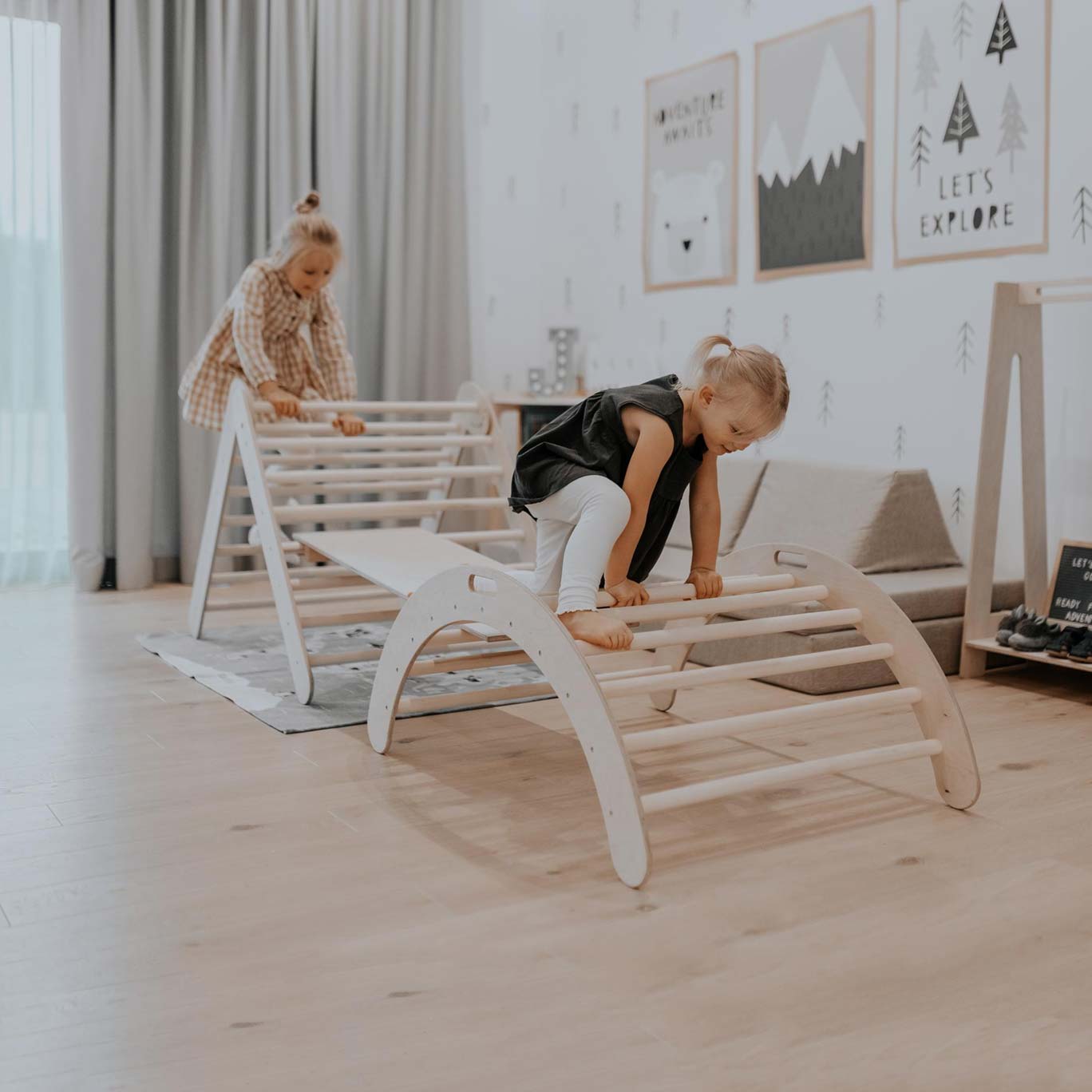 Two children playing on a wooden bed in a room.