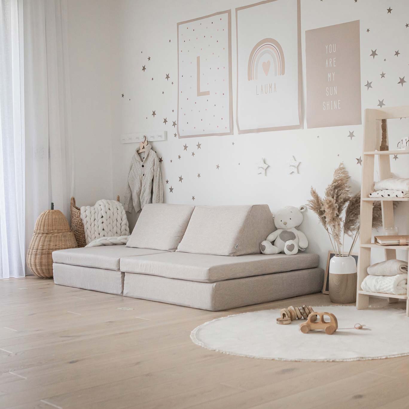 A child's room with a white couch and a wooden floor.