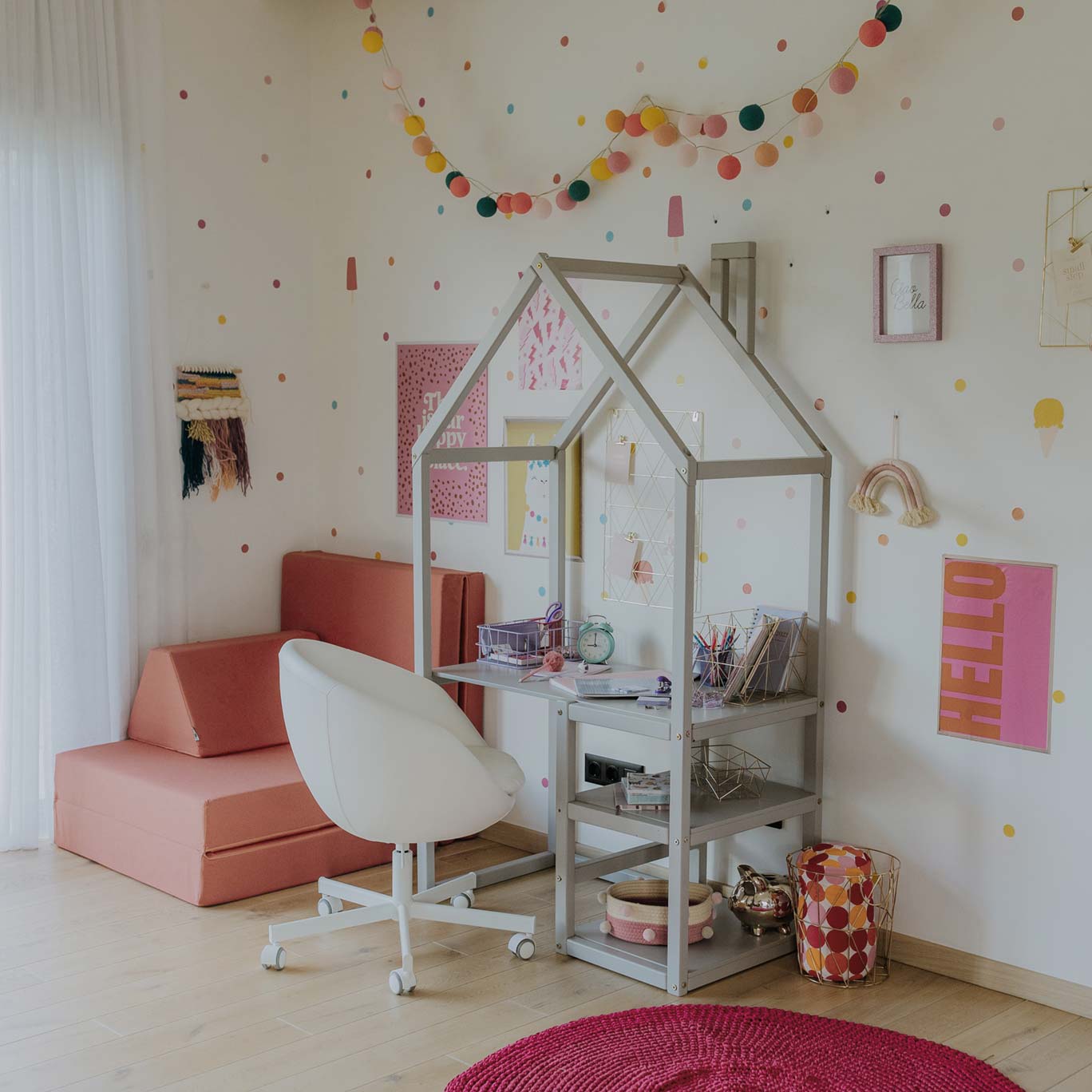 A girl's room with a desk, chair and polka dots.