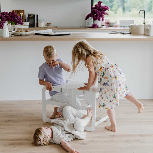 Three children playing on a wooden floor in a Sweet Home From Wood 2-in-1 transformable toddler step stool - table and chair set.
