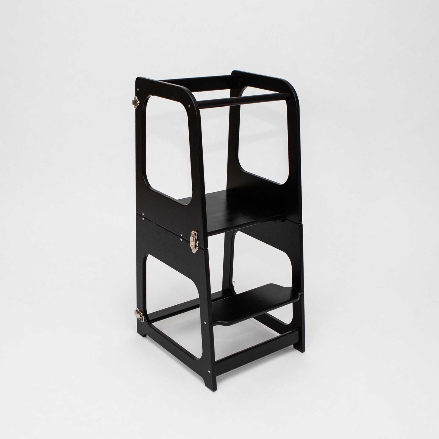A black wooden Sweet Home From Wood kids' 2-in-1 transformable kitchen tower - table and chair with a shelf on top.