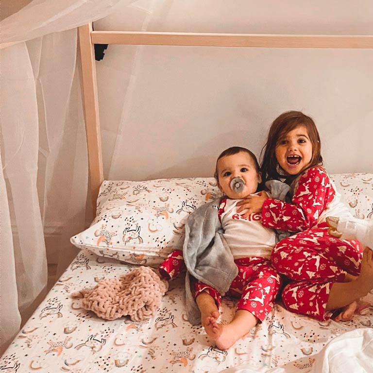 Customer photo of a brother and sister in our floor house bed.