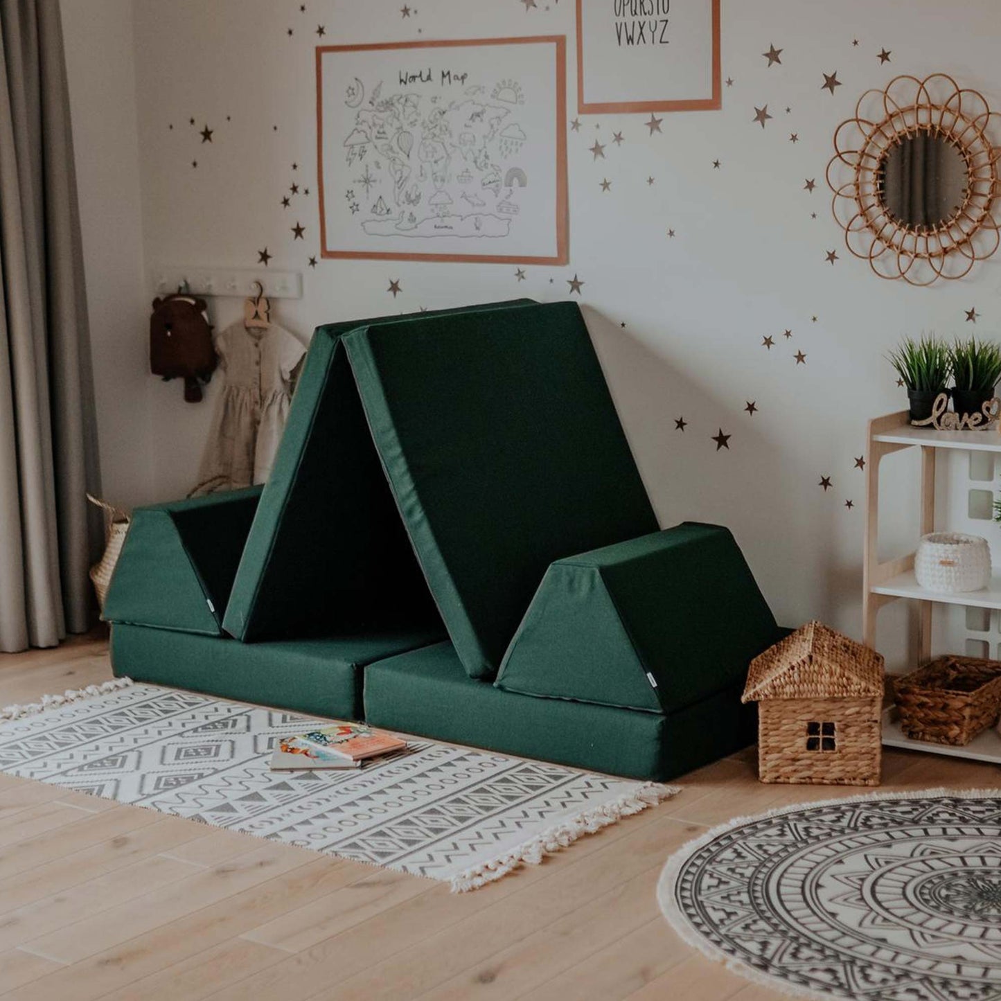 A children's room with a green tent bed, featuring an Activity play couch set from Sweet HOME from wood for kids.