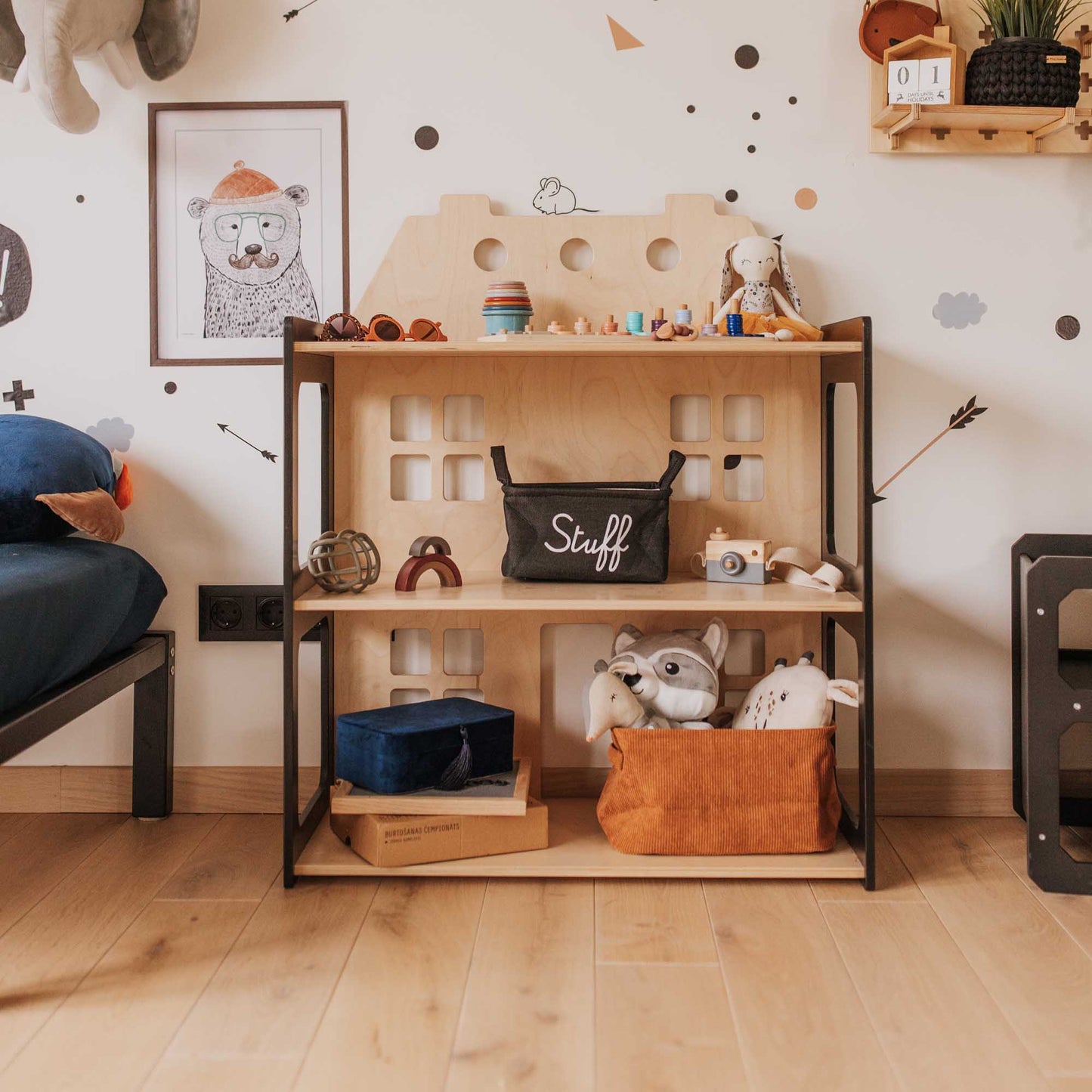 A Sweet Home From Wood 2-in-1 doll house and Montessori shelf with an open toy storage shelf filled with stuffed animals.