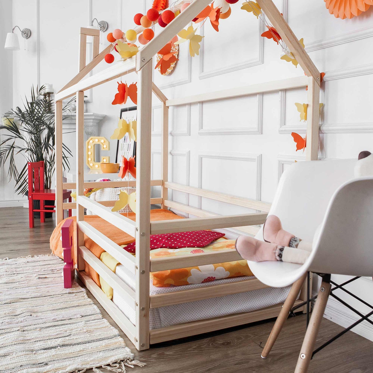 A child's room with a wooden bed and chair.