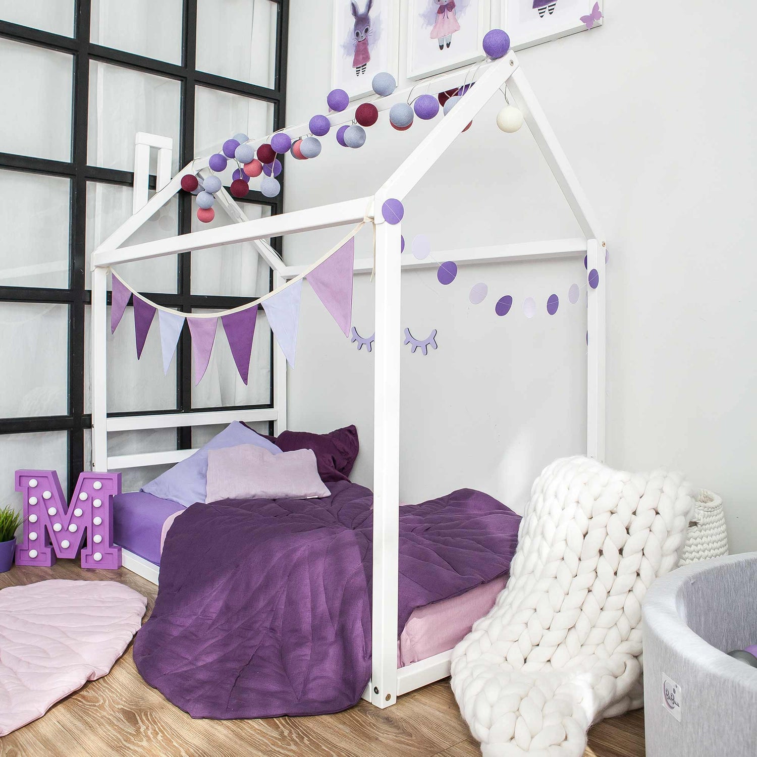 A girl's room with a purple and white bed.