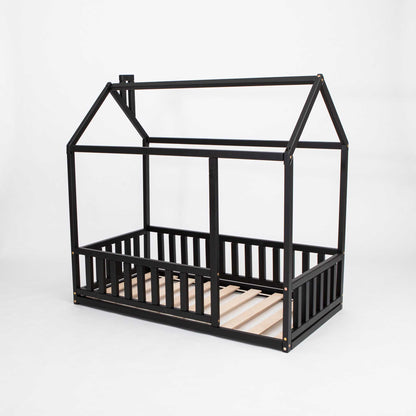 A Sweet Home From Wood Montessori floor house bed with rails, a cozy sleep haven made of black wooden slats.