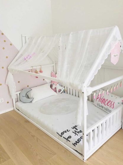 A cozy sleep haven with a Sweet Home From Wood Kids' house-frame bed with 3-sided rails and pink walls.