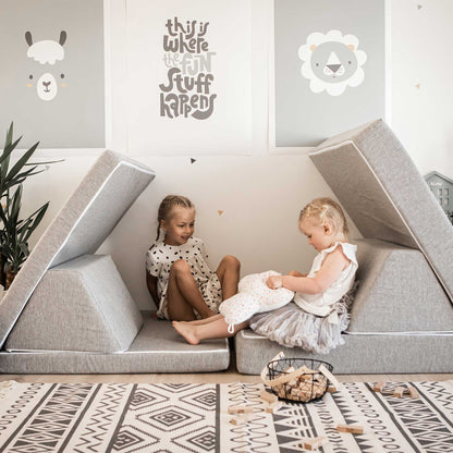 Two babies and toddlers sitting on a Sweet HOME from wood activity play couch set in an indoor play gym.