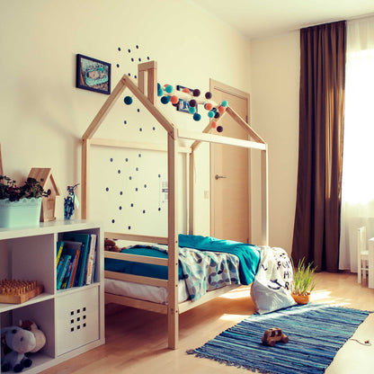 A Kids' house bed on legs with a headboard in a child's room.