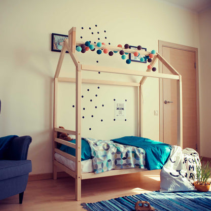 A Kids' house bed on legs with a headboard in a child's room.