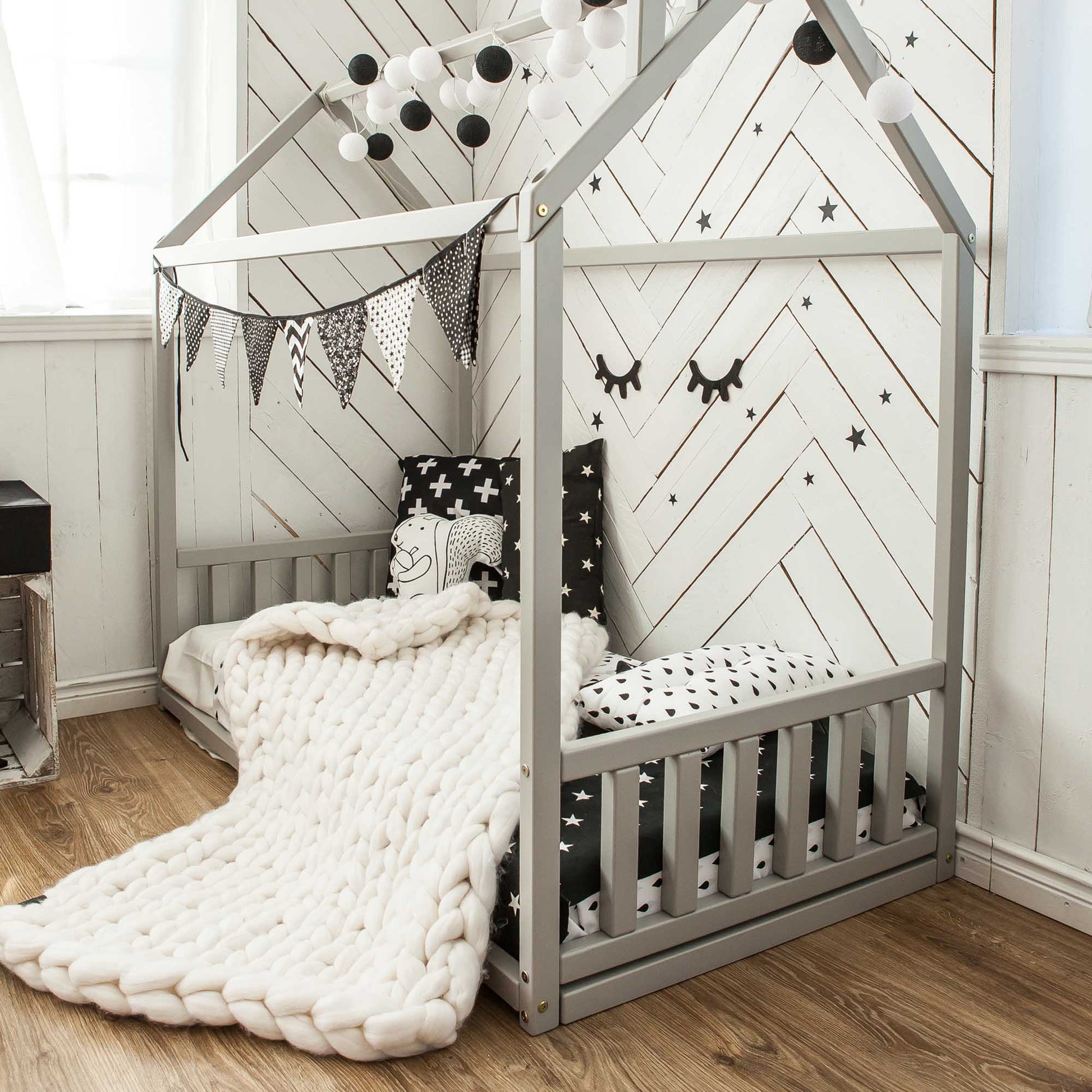 A Sweet Home From Wood Toddler house bed with a headboard and footboard, featuring a stylish black and white design inspired by Montessori, creating a sleep haven.