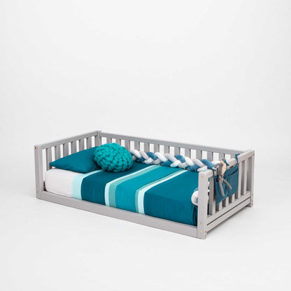 A Sweet Home From Wood 2-in-1 toddler bed on legs with a 3-sided vertical rail made of solid pine or birch wood with a blue and white striped blanket.