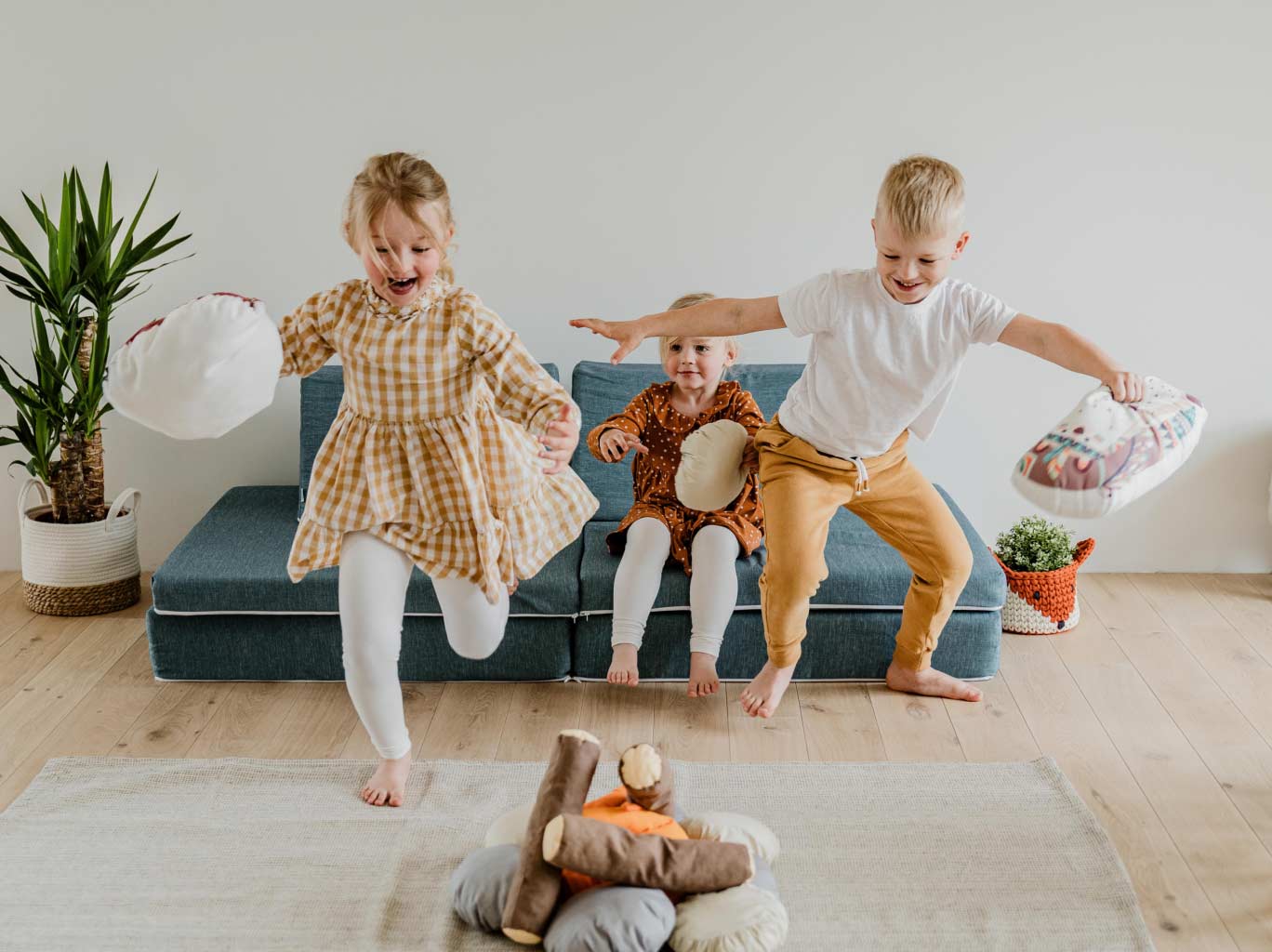 Three children playing with toys in a living room.