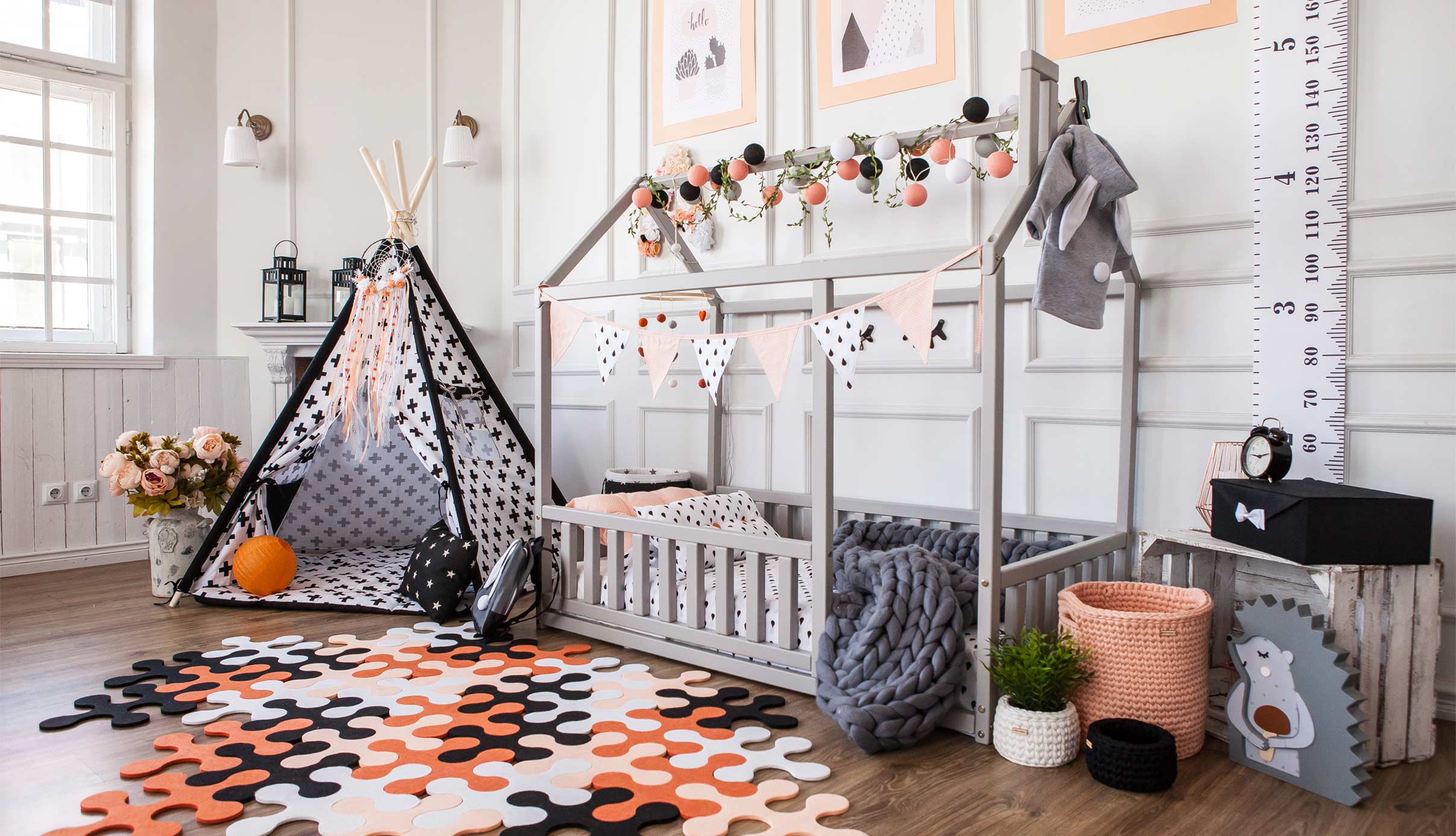 A room decorated for halloween with a teepee, a teddy bear and a teddy.