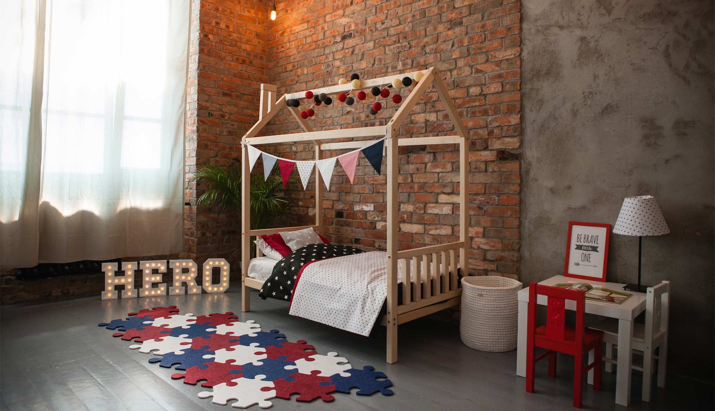 A child's bedroom with a wooden bed and a brick wall.